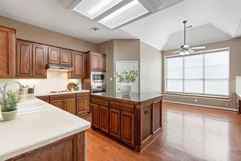 a kitchen with stainless steel appliances granite countertop a sink and wooden cabinets