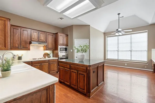 a kitchen with stainless steel appliances granite countertop a sink and wooden cabinets