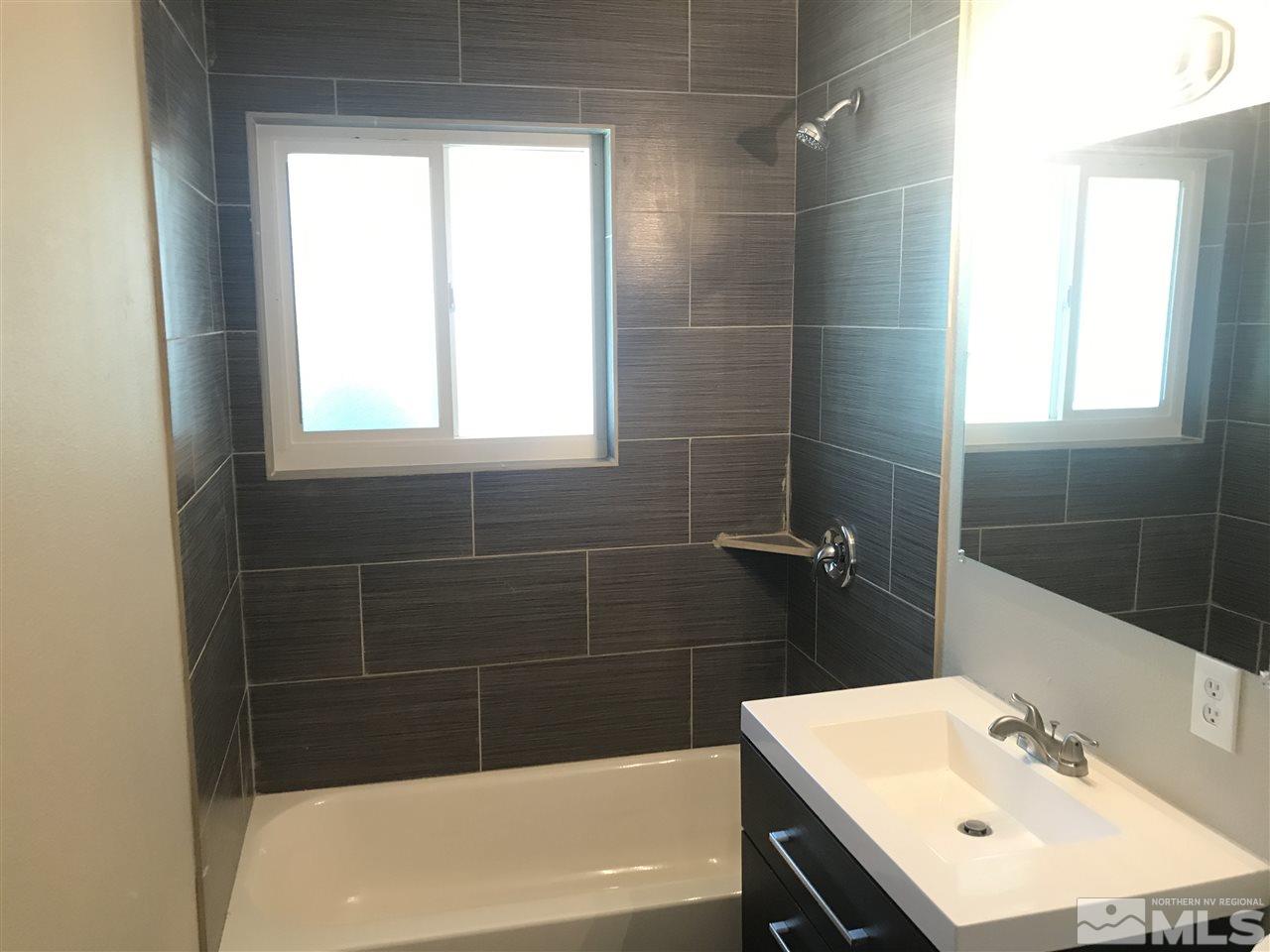 1480 Elizabeth Street Reno, NV 89509 - Photo 12 of 16 a bathroom with a bathtub a sink a window and vanity
