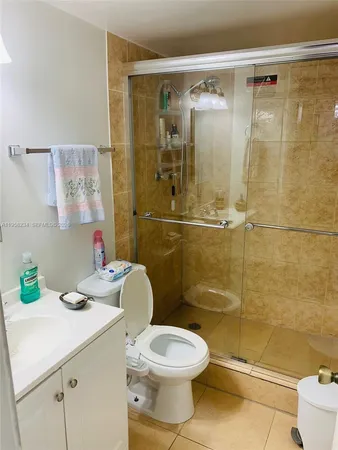 a bathroom with a granite countertop toilet sink and shower