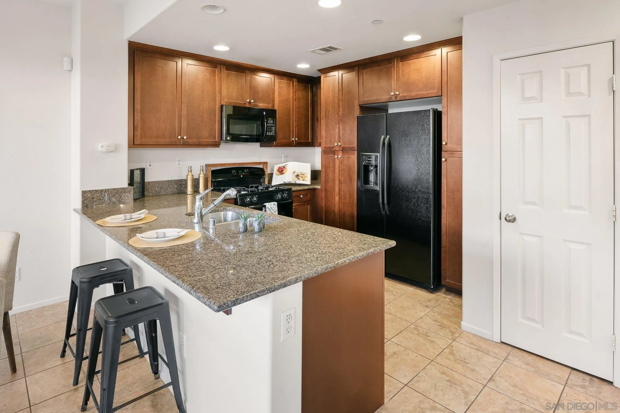 1402 Calabria Street Santee, CA 92071 - Photo 13 of 40 a kitchen with stainless steel appliances granite countertop a sink a microwave a refrigerator and a stove