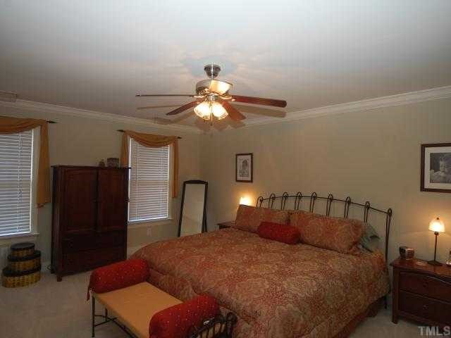 5313 Levering Mill Road Apex, NC 27539 - Photo 8 of 12 a bedroom with bed and a chandelier