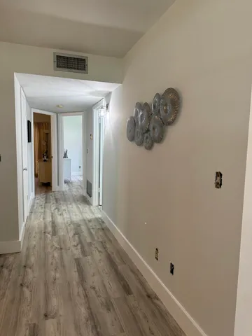 a view of a hallway with wooden floor
