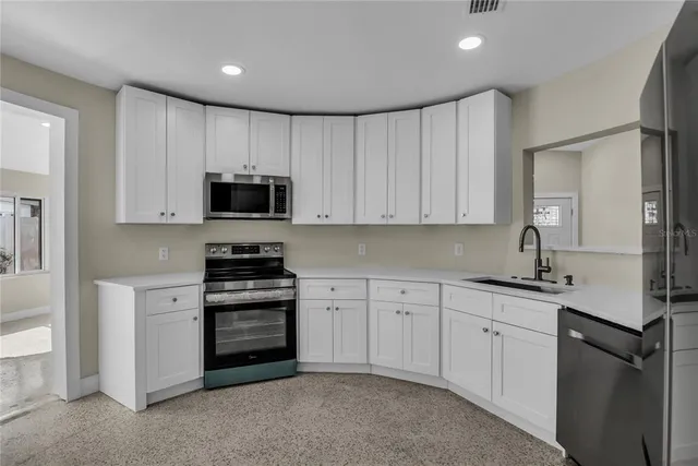 a kitchen with stainless steel appliances granite countertop a refrigerator sink and cabinets