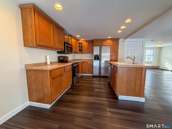 a kitchen with wooden floors and white cabinets