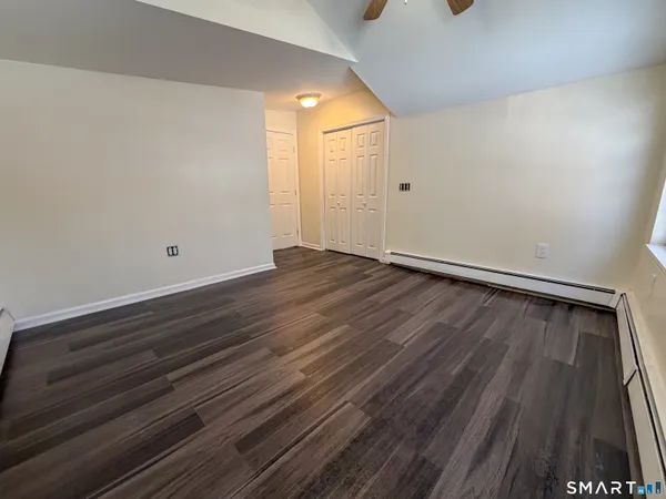 a view of an empty room with wooden floor