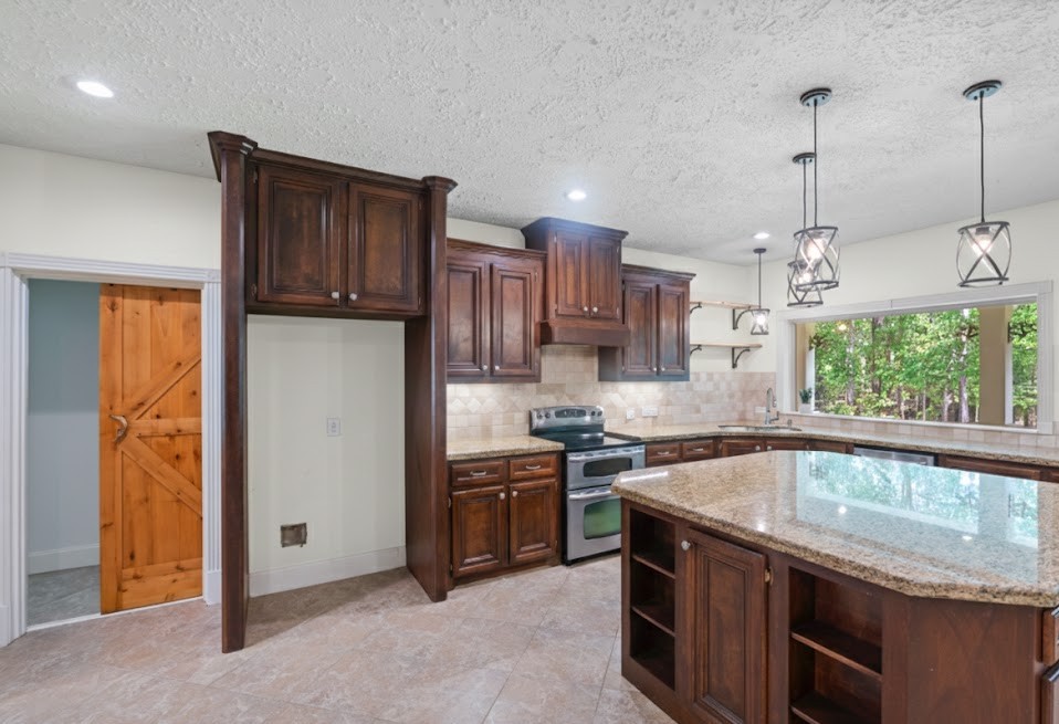 519 Dodge-Oakhurst Road Huntsville, TX 77320 - Photo 15 of 50 a kitchen with stainless steel appliances granite countertop a sink a stove and a refrigerator