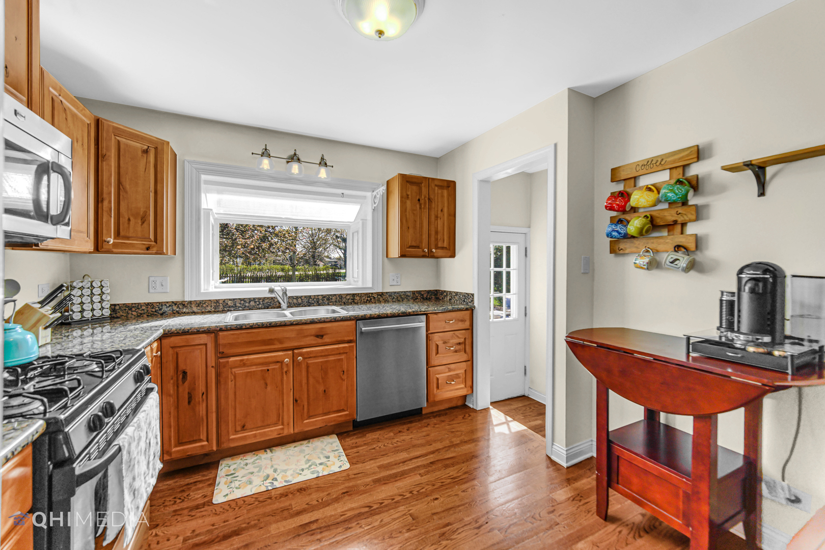 509 4th Street Lemont, IL 60439 - Photo 8 of 34 a kitchen with stainless steel appliances granite countertop a stove top oven a sink a dining table and chairs with wooden floor