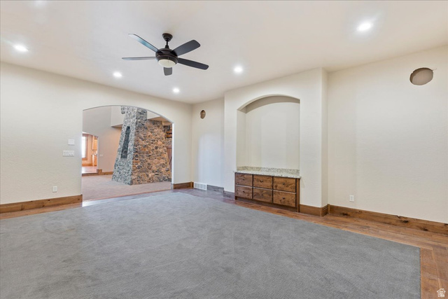 246 Woods Creek Road Morgan, UT 84050 - Photo 23 of 69 Recessed lighting, ceiling fan, arched doorway, built-in cabinetry with stone-finish countertop, and wood-finish flooring