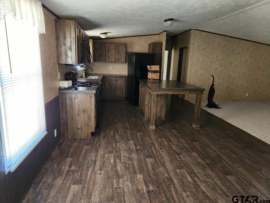 6339 Gorilla Road Gilmer, TX 75644 - Photo 12 of 12 a kitchen with sink a refrigerator and wooden floor