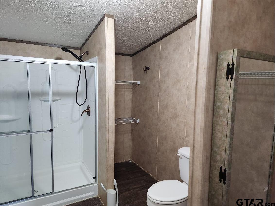6339 Gorilla Road Gilmer, TX 75644 - Photo 3 of 12 a bathroom with a toilet and a shower