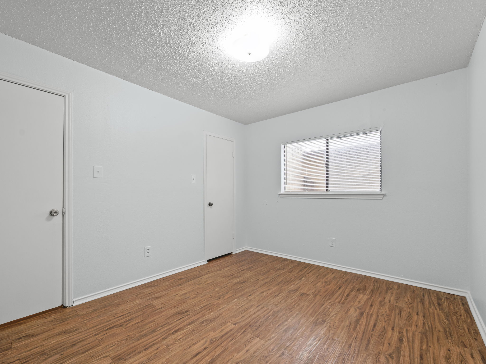 1816 Rawhide Loop, Unit 1822 Round Rock, TX 78681 - Photo 13 of 17 Unfurnished room with wood finished floors and a textured ceiling