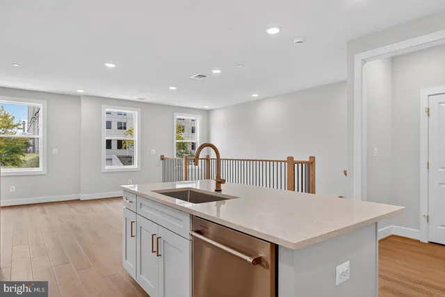 a kitchen with stainless steel appliances granite countertop a sink and a large window
