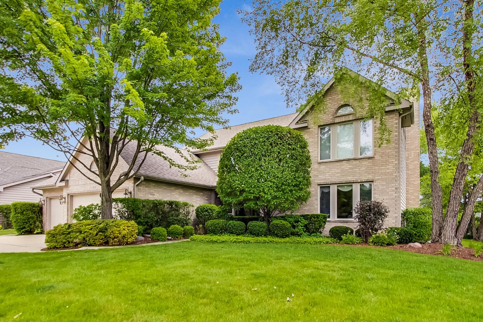 a front view of a house with a garden and plants