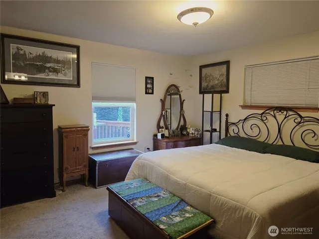 a bedroom with a bed a table and painting on the wall