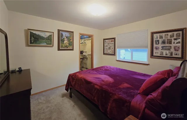 a bedroom with a bed and painting on the wall