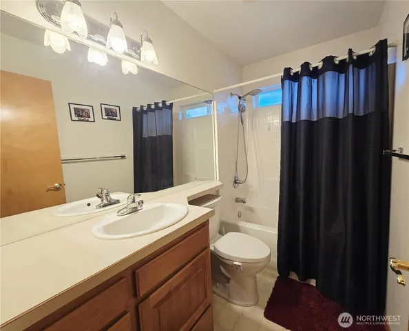a bathroom with a sink a toilet a large mirror and shower