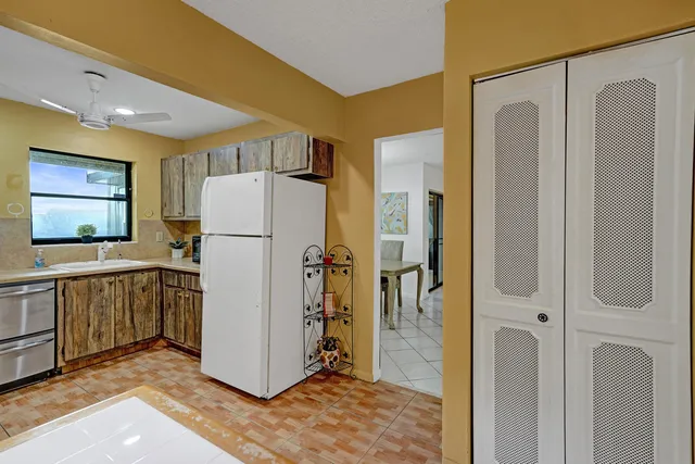 a view of kitchen with a refrigerator cabinets and wooden floor