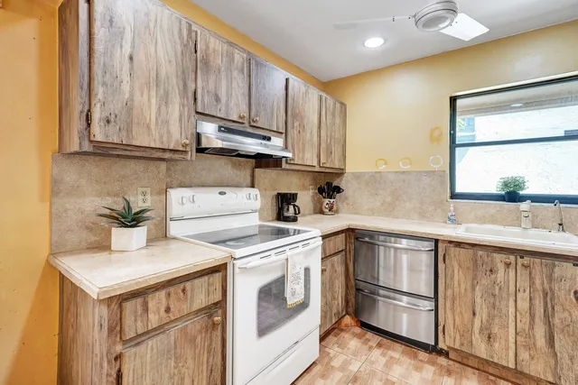a kitchen with stainless steel appliances granite countertop a sink a stove and cabinets