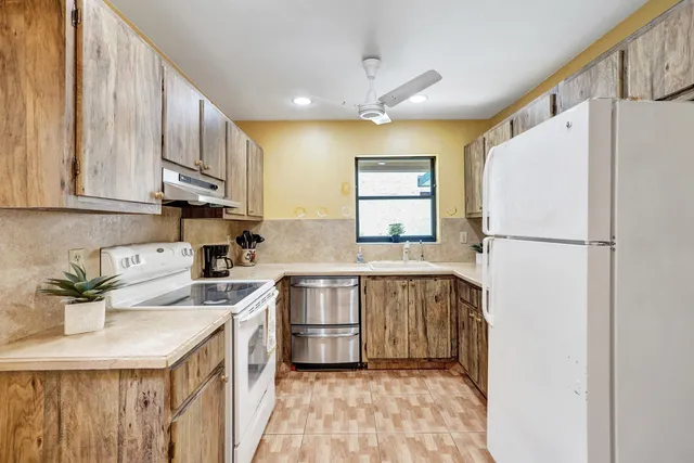 a kitchen with stainless steel appliances granite countertop a refrigerator sink and cabinets
