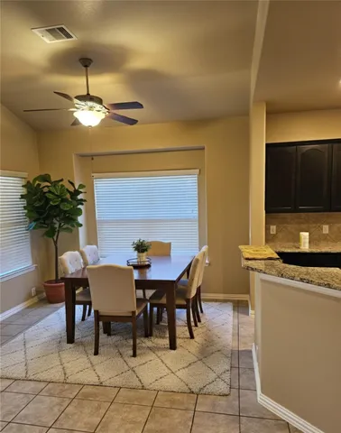 a dining room with furniture a potted plant and a chandelier