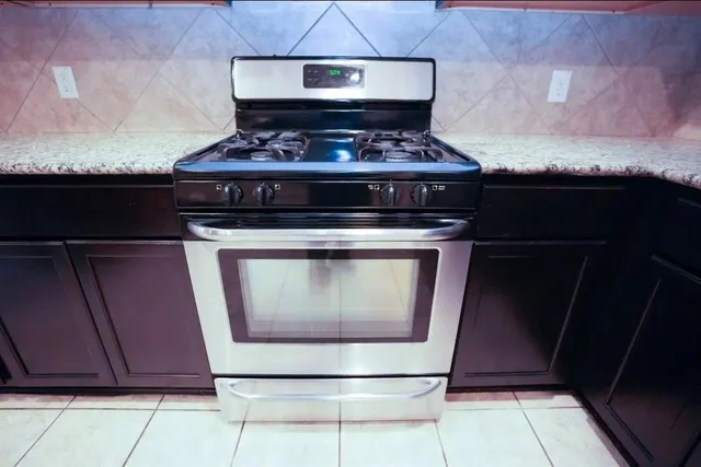 a stove top oven sitting inside of a kitchen