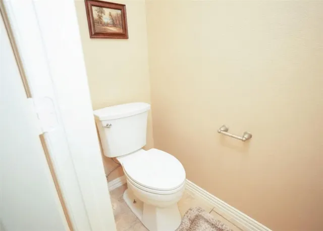 a white toilet sitting next to a shower