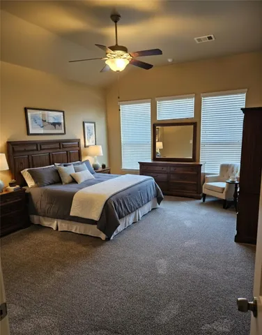 a spacious bedroom with a bed and a chandelier