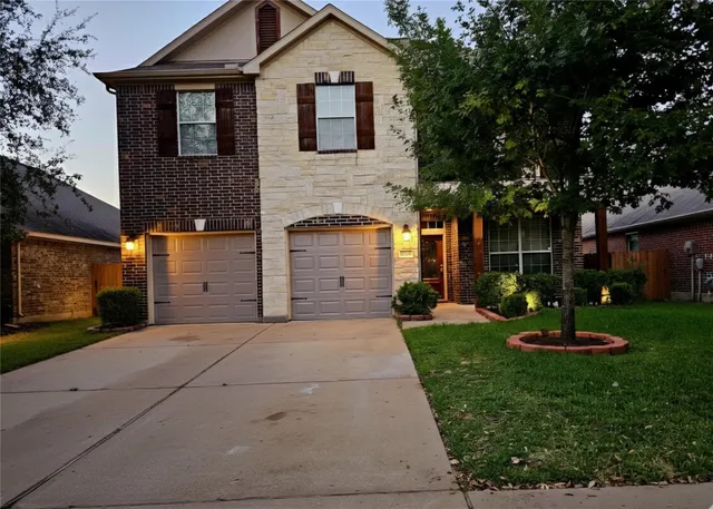 a front view of a house with a yard and trees