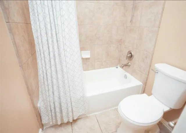 a white toilet sitting next to a bath tub