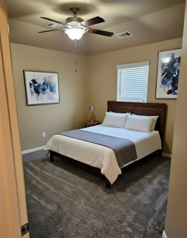 a bedroom with a bed and a painting on the wall