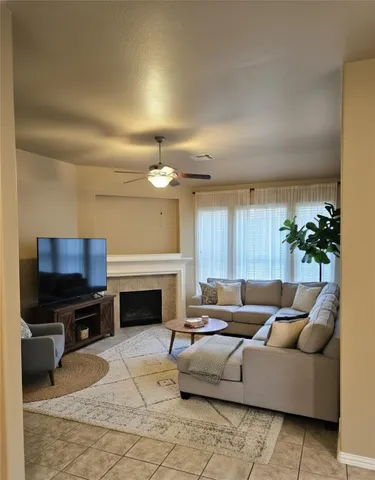 a living room with furniture a fireplace and a flat screen tv