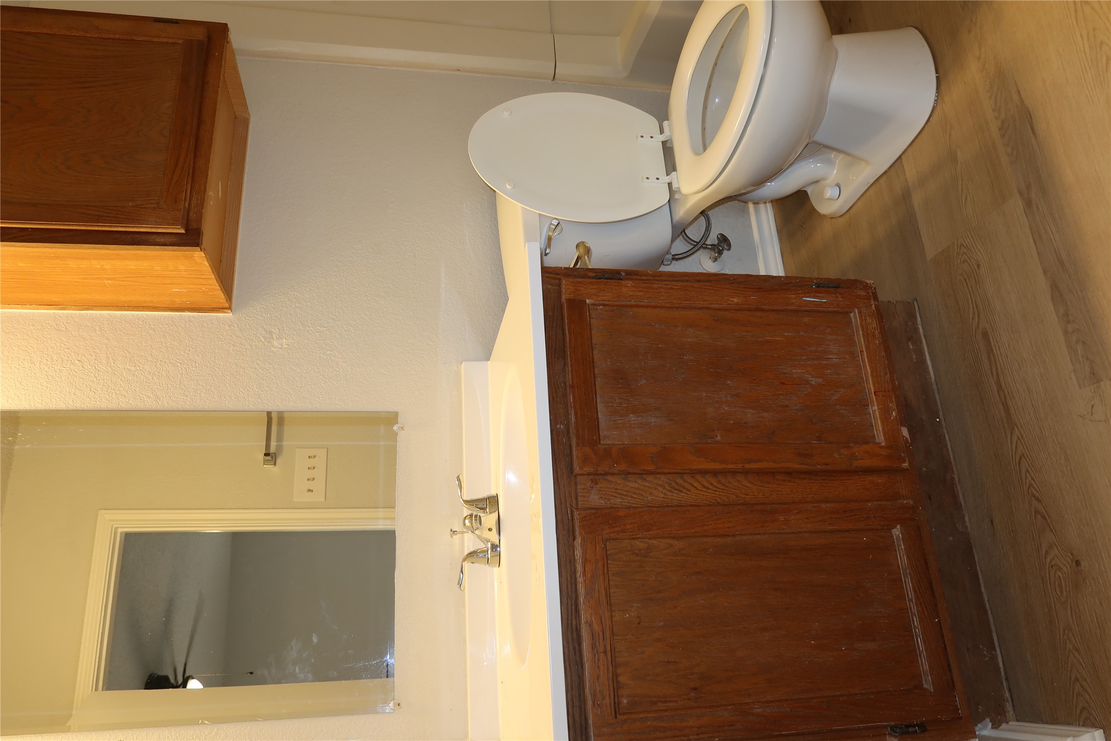 2511 Bucks Run, Unit A Austin, TX 78744 - Photo 12 of 25 Half bathroom with vanity, dark wood finished floors, and a ceiling fan