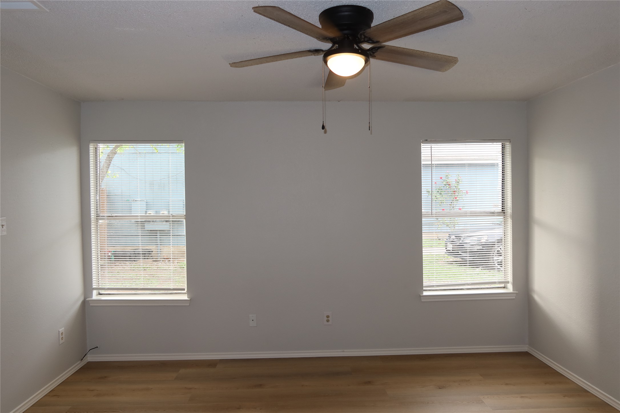 2511 Bucks Run, Unit A Austin, TX 78744 - Photo 14 of 25 Empty room featuring a ceiling fan, light wood-style floors, and plenty of natural light