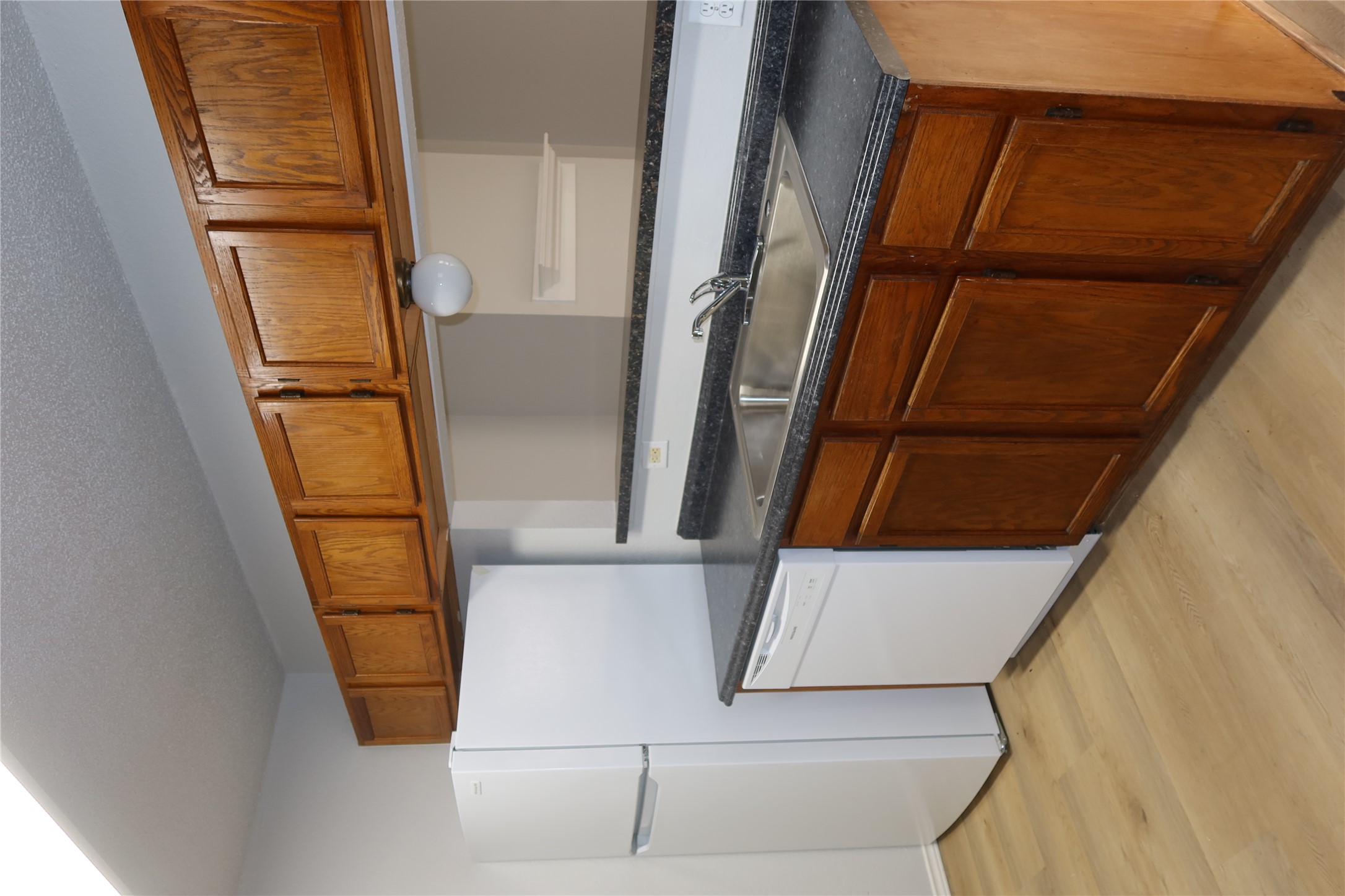 2511 Bucks Run, Unit A Austin, TX 78744 - Photo 6 of 25 Kitchen with light wood-style flooring, white appliances, a textured ceiling, and wood finish cabinetry