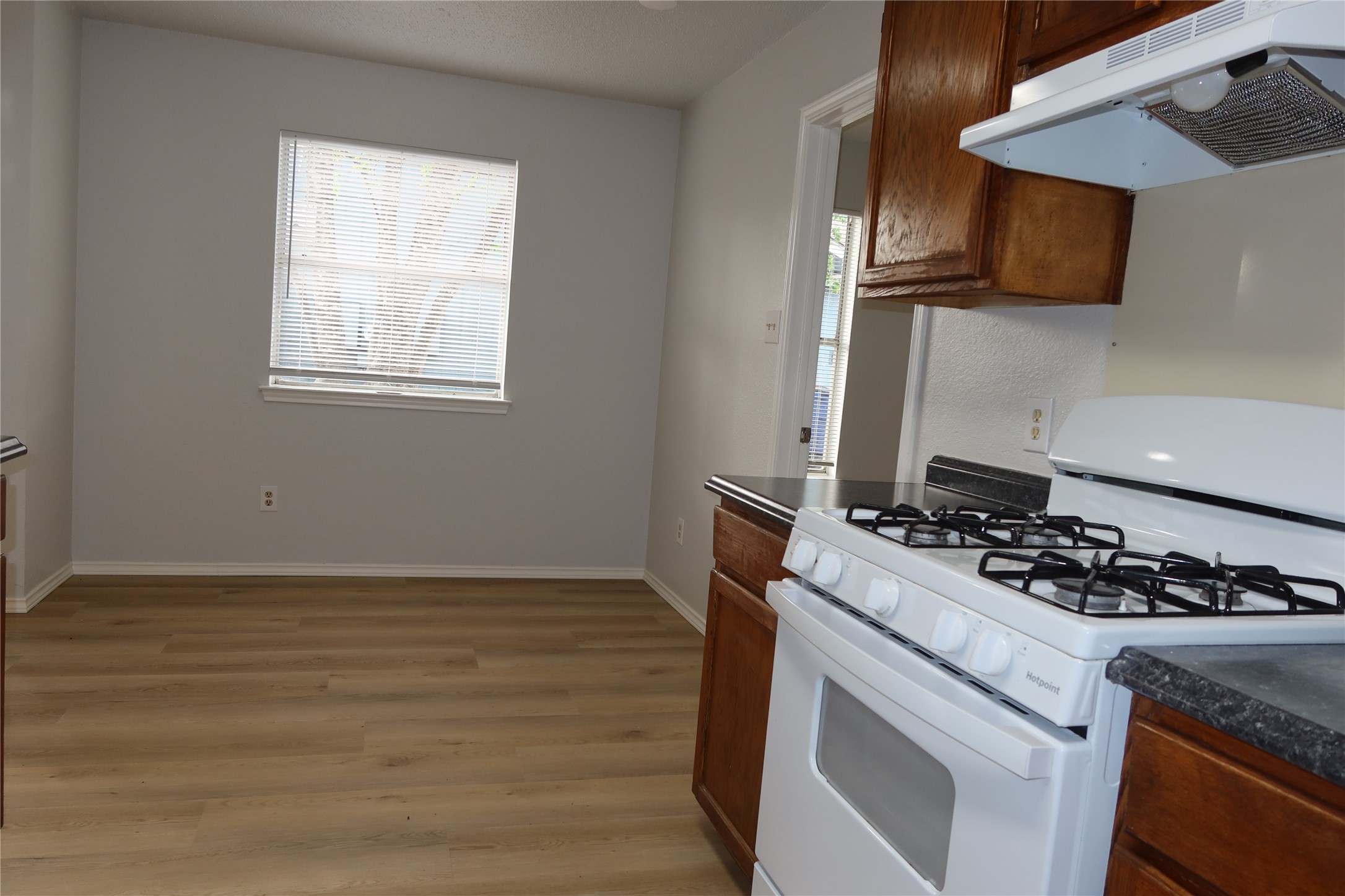 2511 Bucks Run, Unit A Austin, TX 78744 - Photo 8 of 25 Kitchen with white gas range, light wood-style flooring, and wood finish cabinetry