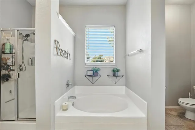 a spacious bathroom with a tub sink and mirror