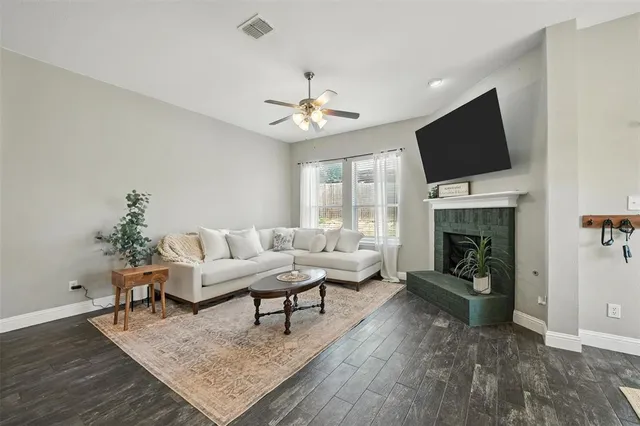 a living room with furniture a fireplace and a flat screen tv