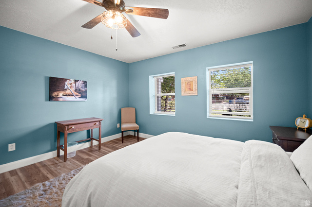 236 West 300 South Hurricane, UT 84737 - Photo 28 of 76 Spacious room featuring wood-finish flooring, two windows with blinds, a ceiling fan with integrated lighting, and light blue walls