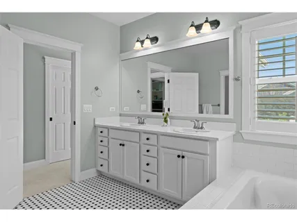 a bathroom with a tub sink and mirror
