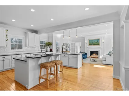 a living room with stainless steel appliances kitchen island granite countertop furniture and fireplace