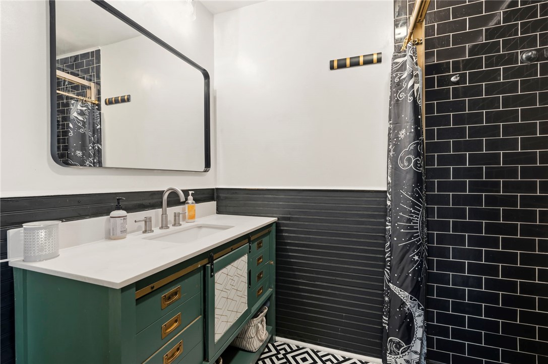 122 Latham Drive Anderson, SC 29621 - Photo 17 of 40 This primary bathroom boasts a sophisticated vanity, sleek fixtures, and striking tile accents for a modern appeal.