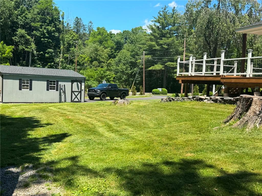 164 Sand Spring Road Cresco, PA 18326 - Photo 22 of 60 A detached shed and elevated deck complement the spacious, verdant yard, offering functional outdoor living.