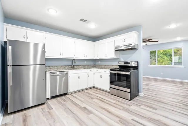 a kitchen with stainless steel appliances a refrigerator sink and stove