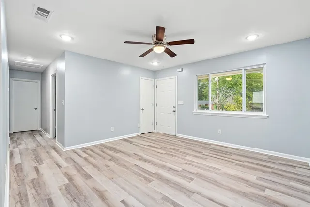 a view of empty room with window and ceiling fan