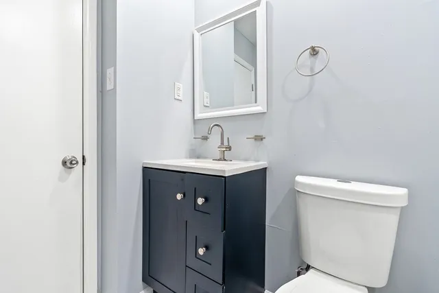 a bathroom with a toilet sink and mirror