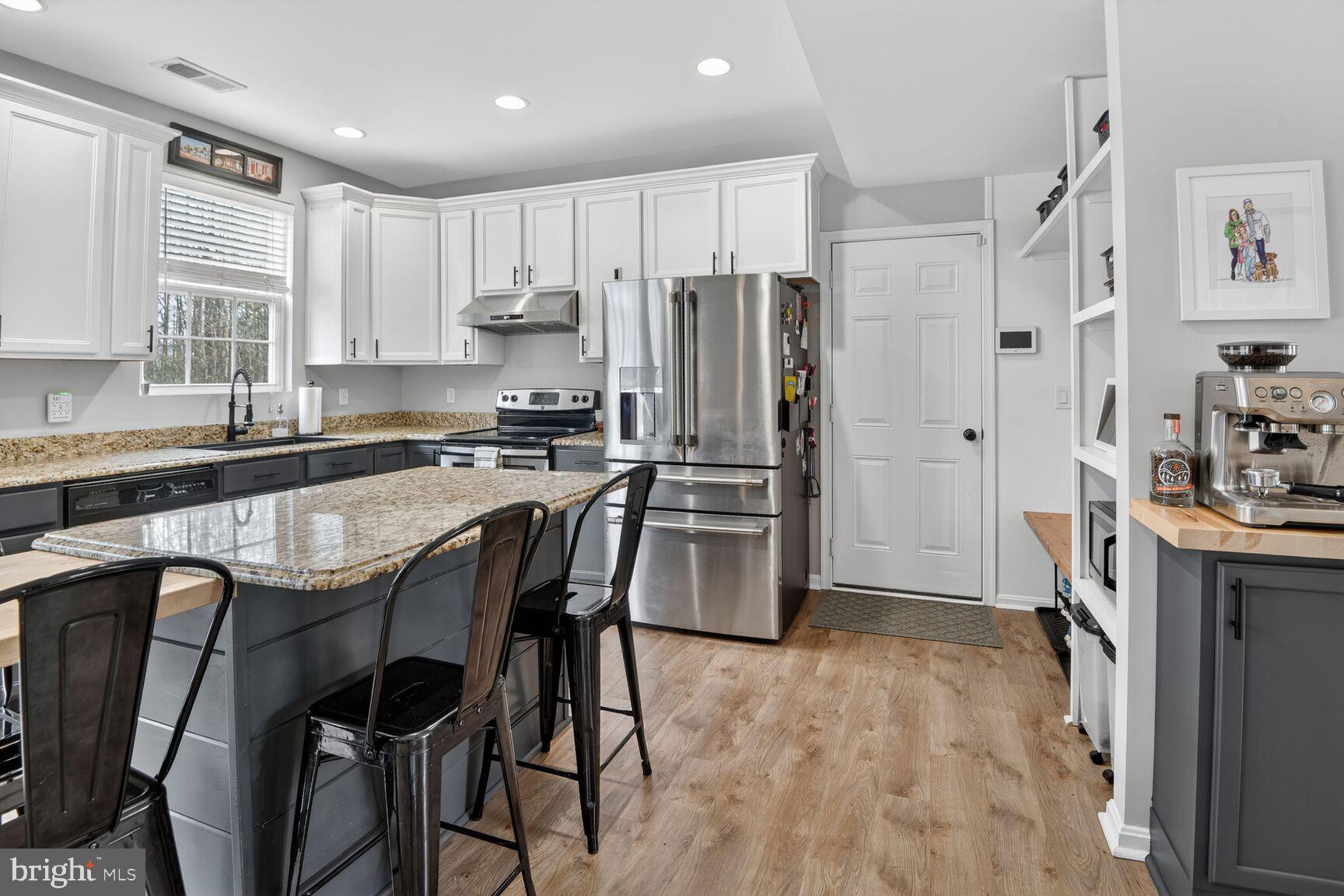 1409 James Way Edgewater, MD 21037 - Photo 6 of 21 a kitchen with stainless steel appliances granite countertop a refrigerator a sink a stove a dining table and chairs