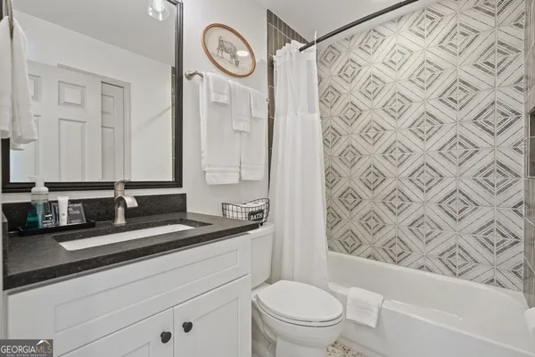 a bathroom with a granite countertop sink mirror vanity and toilet