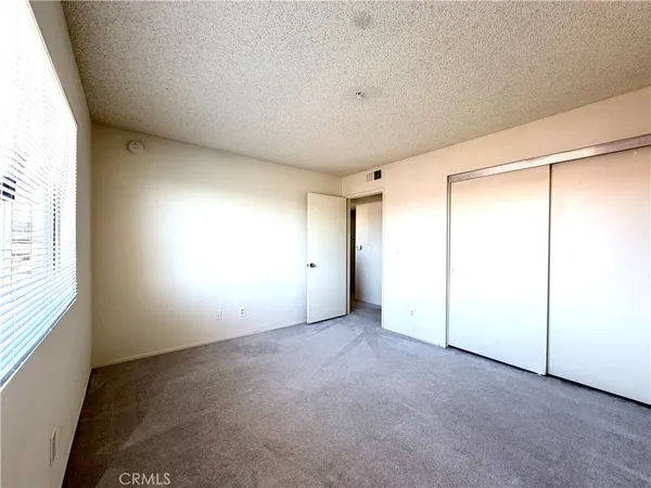 an empty room with windows and closet