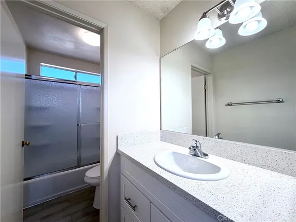 a bathroom with a sink a toilet and a mirror